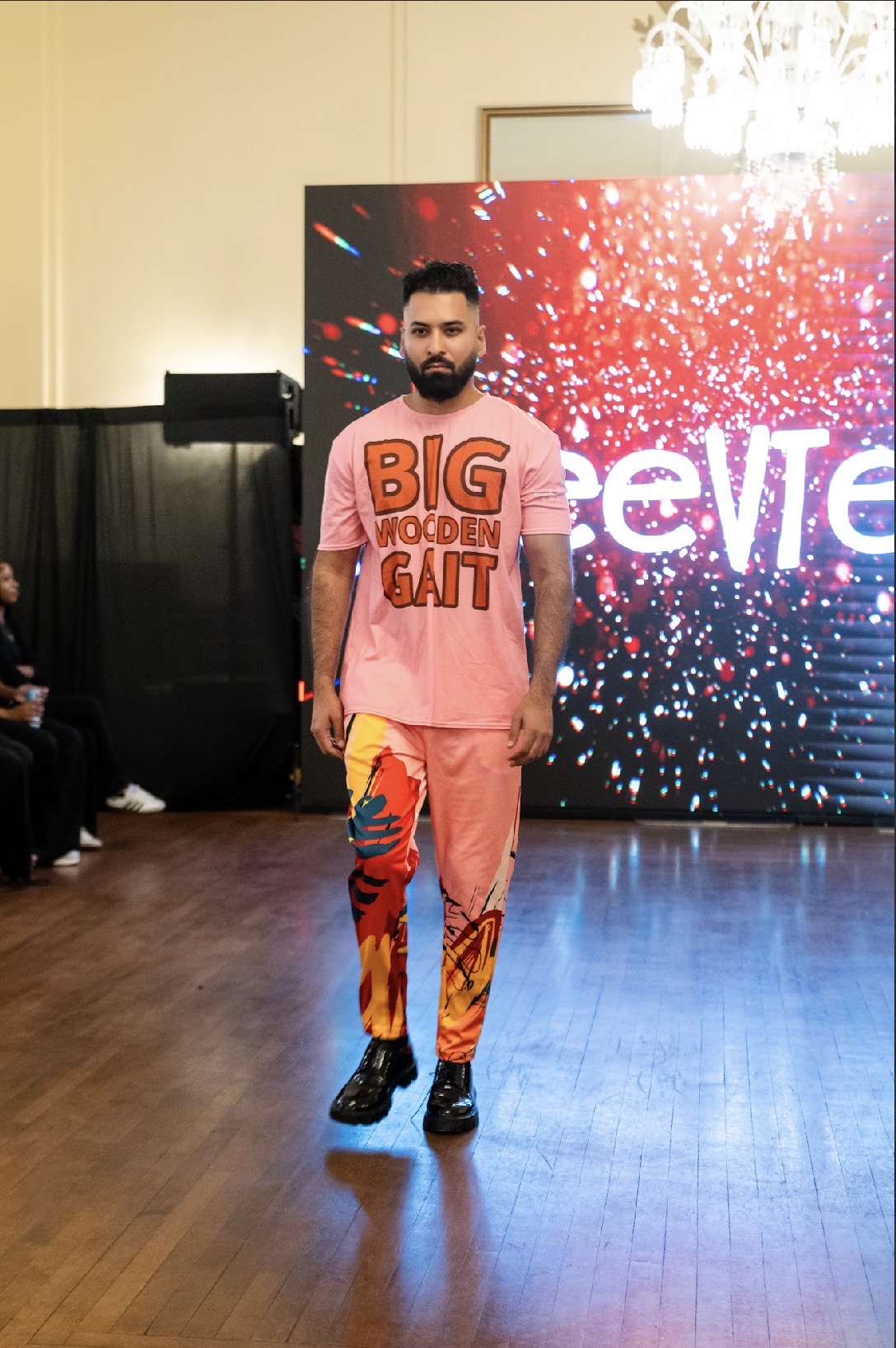 Model Arjun Pandey in a pink graphic streetwear look with printed trousers on the Season 05 runway