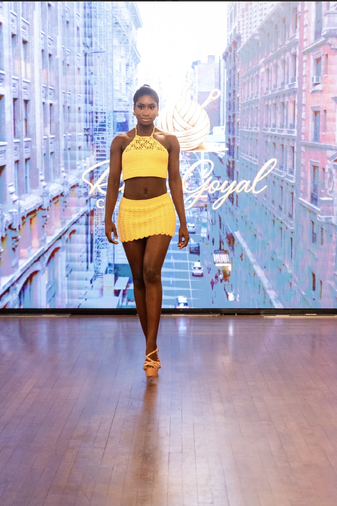 Model in a yellow crochet two-piece walking the Season 05 runway