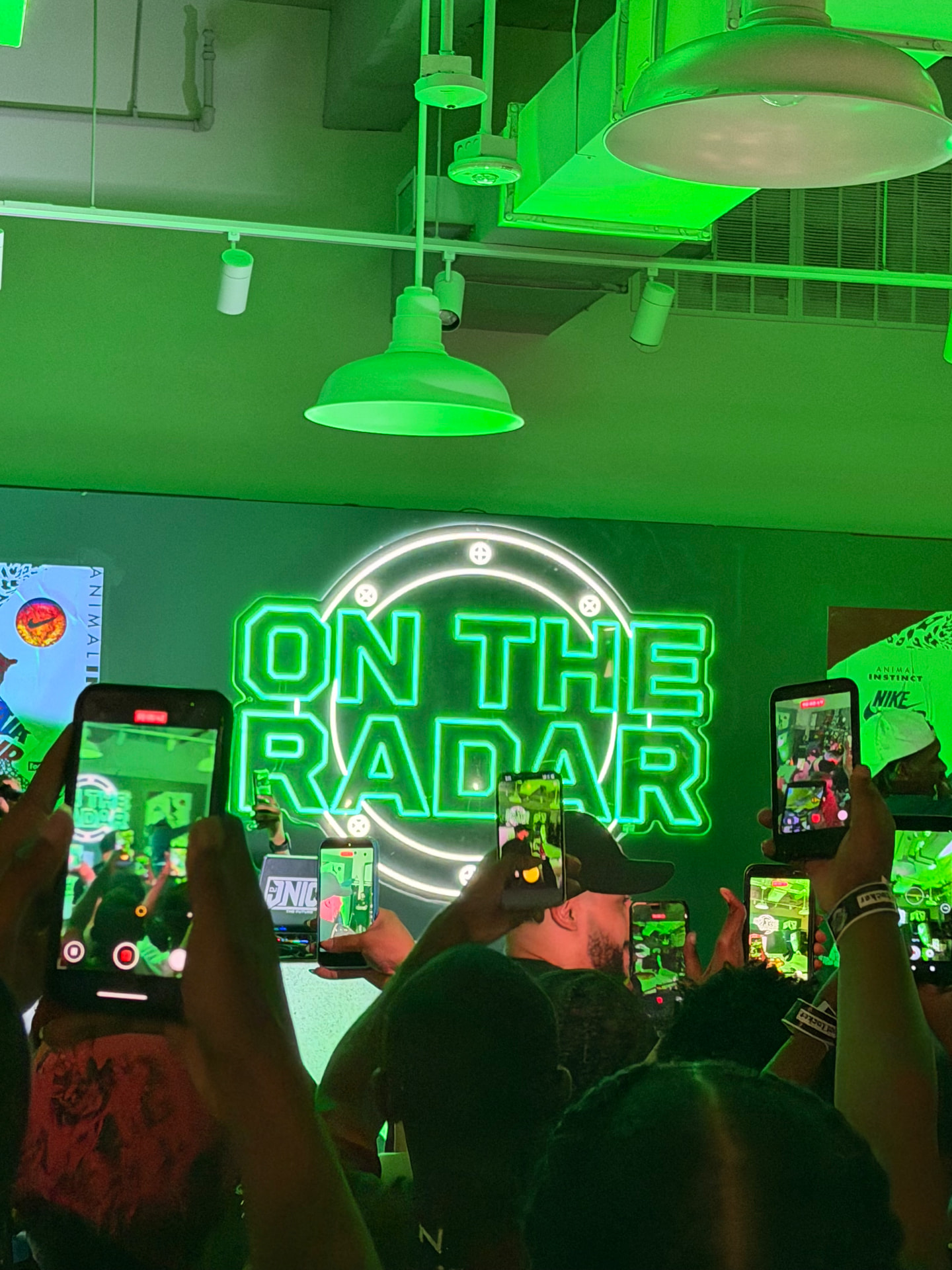 The illuminated ON THE RADAR sign as the crowd raises phones to record the performance