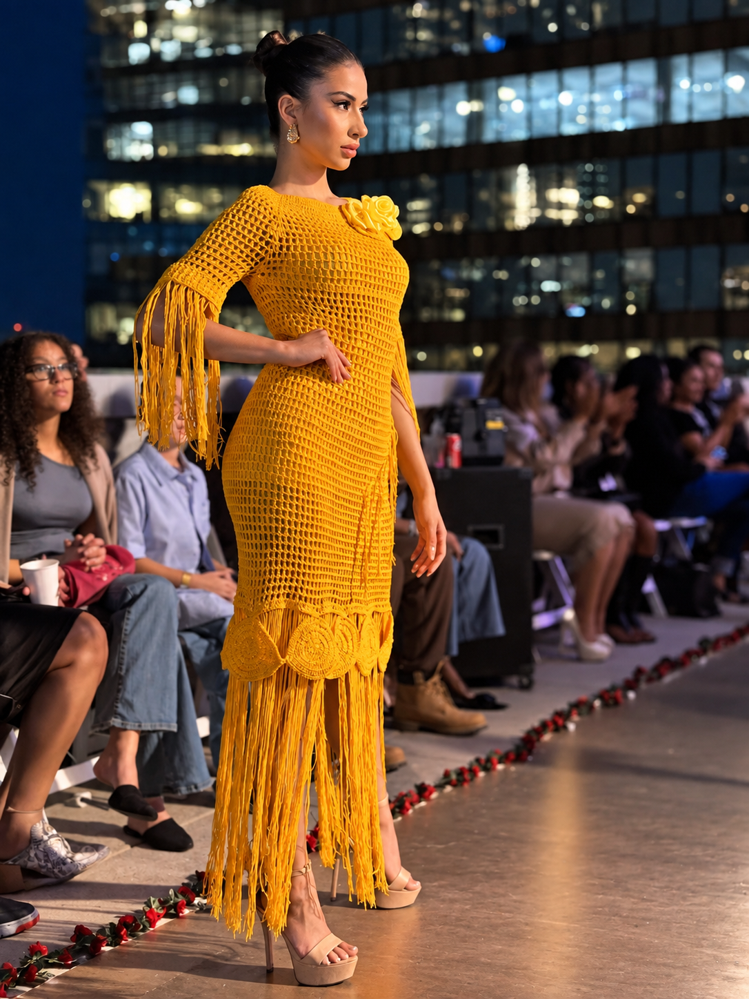 Model on the Designer Dream Collection runway in an orange-gold crochet dress with fringe detailing