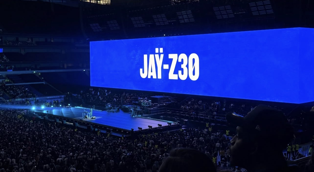 A packed London arena during JAY-Z's show, with a large blue screen reading JAY-Z30 above the stage