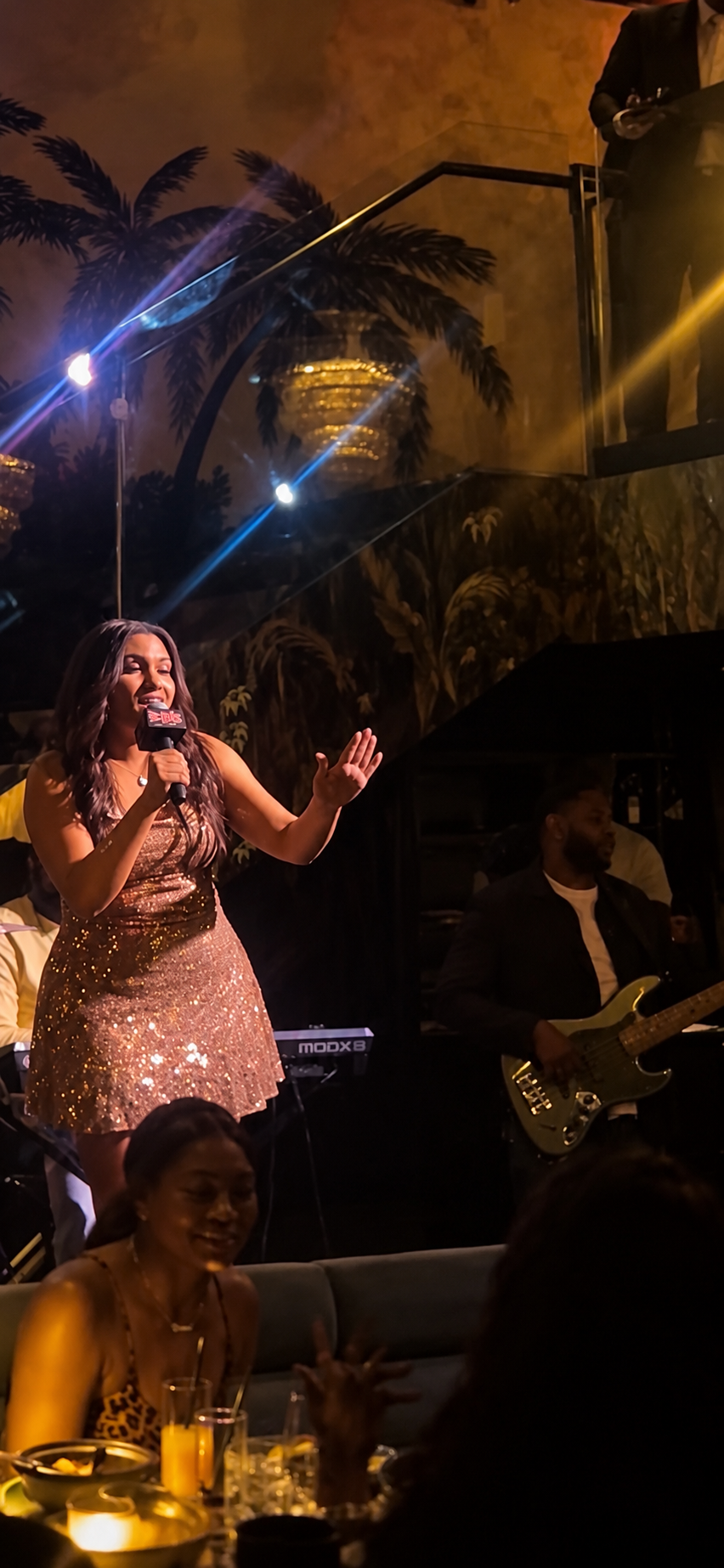 Angelina Thompson performs with the live band as the audience looks on