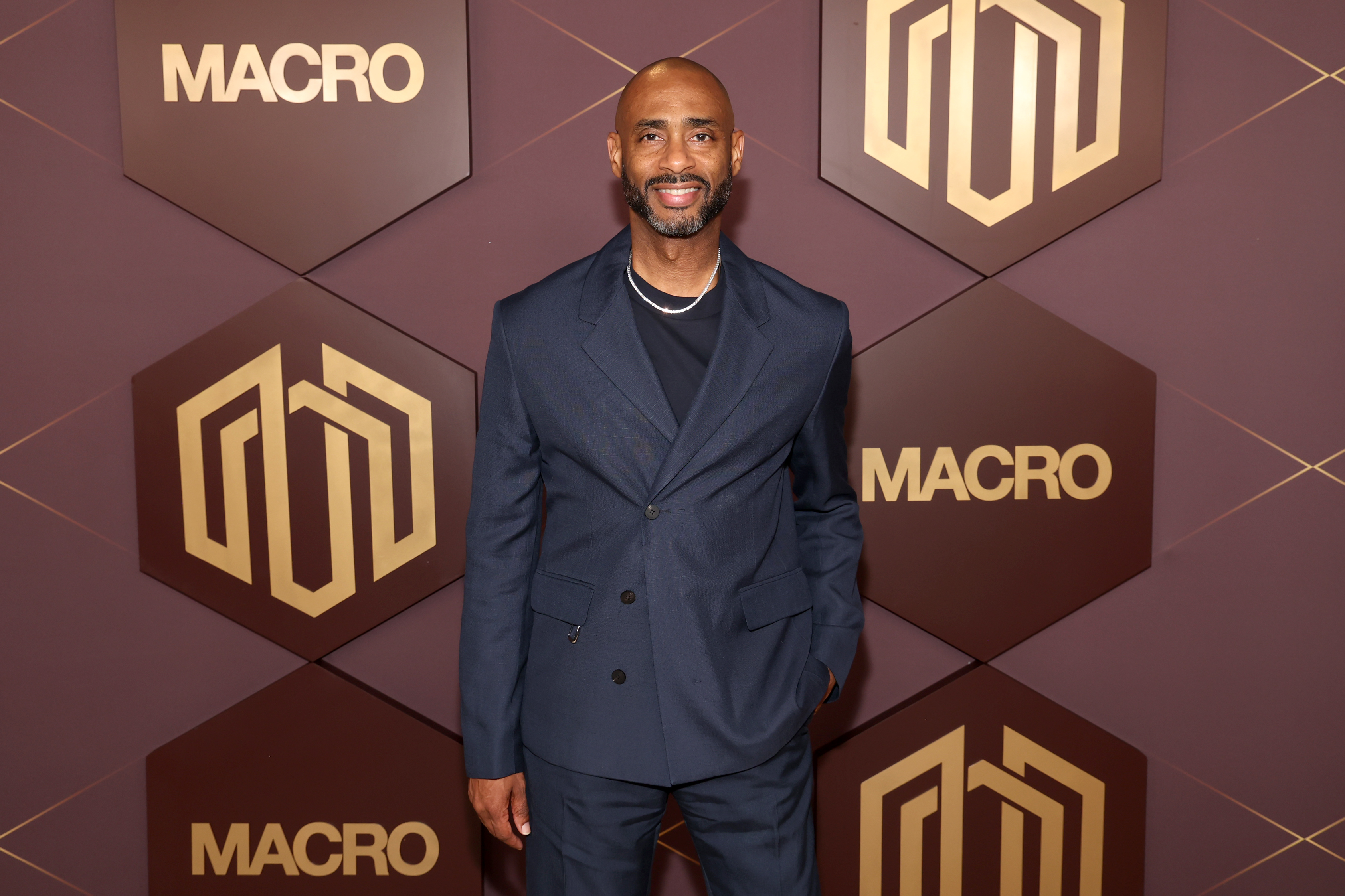 Charles D. King photographed in front of MACRO signage at an entertainment industry event.